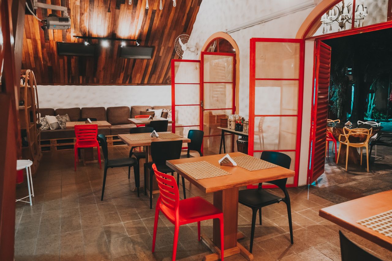 The Art of Drawing Readers In: Your attractive post title goes here Warm, inviting restaurant interior featuring red accents, wooden walls, and cozy seating, ideal for dining in comfort.