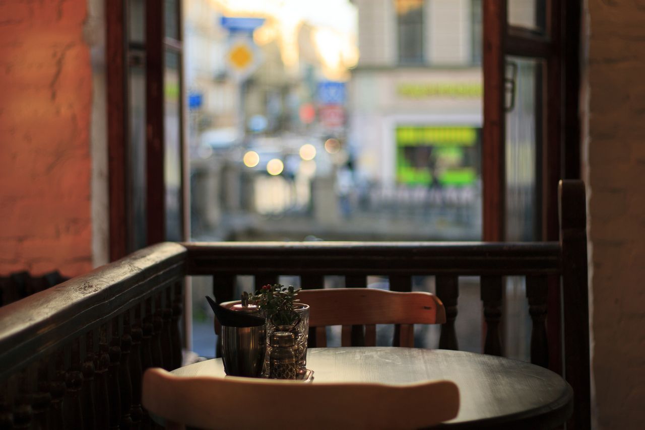 Mastering the First Impression: Your intriguing post title goes here Charming cafe setting with outdoor city view through window, creating a warm ambiance.