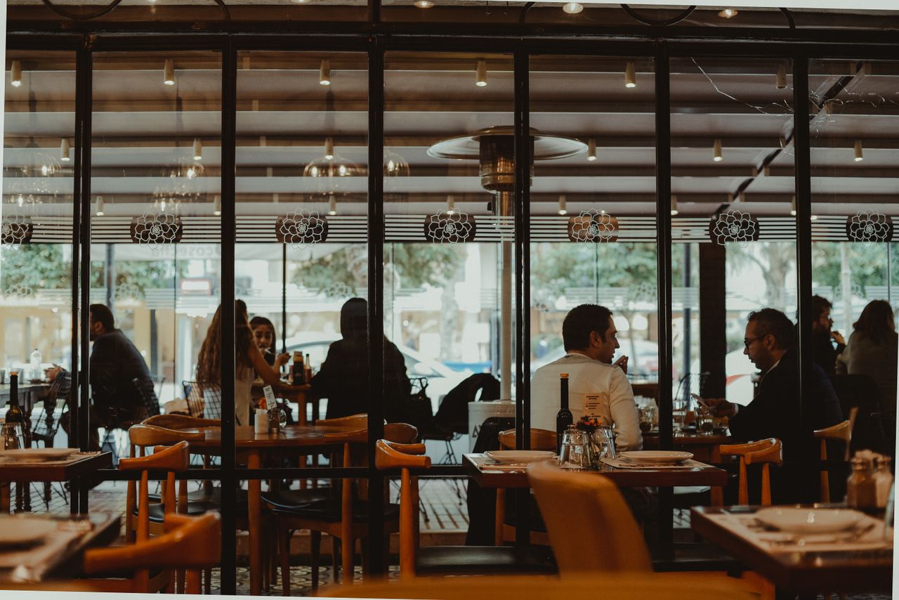 why-choose-us A bustling restaurant interior showcasing diners enjoying their meals in a cozy atmosphere.